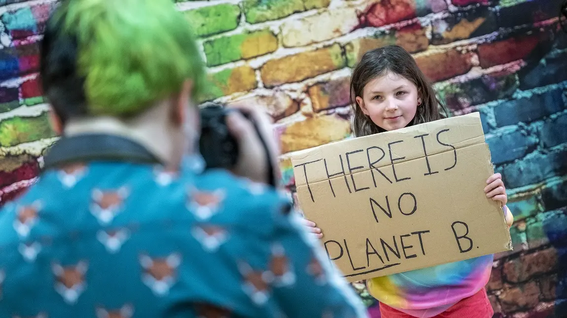 NHLF_Summerlee_1.JPG A child having their photograph taken, holding up a cardboard sign that reads: There is no planet B