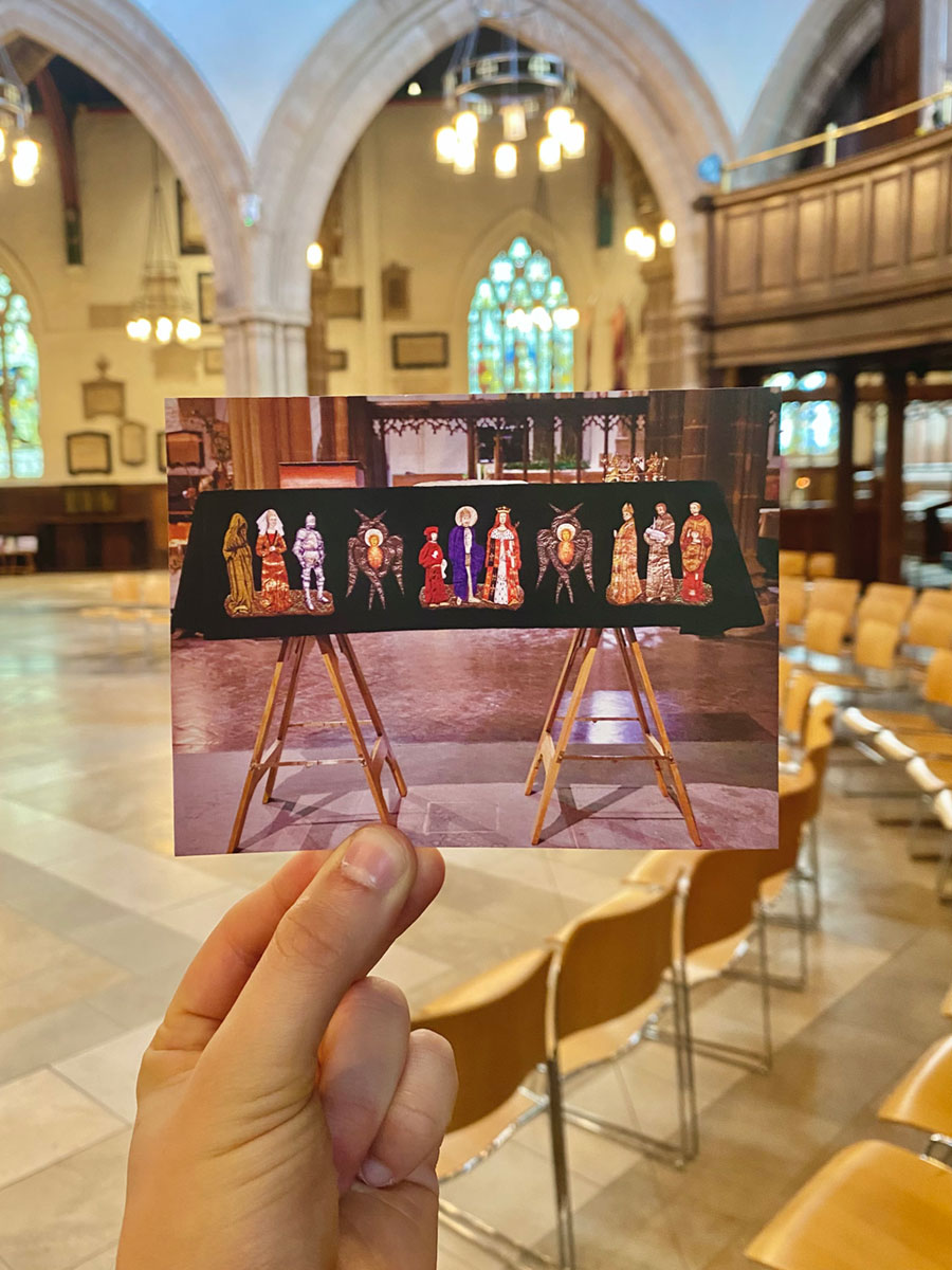 A hand holding a photograph of a coffin on display in a cathedral, within that same cathedral