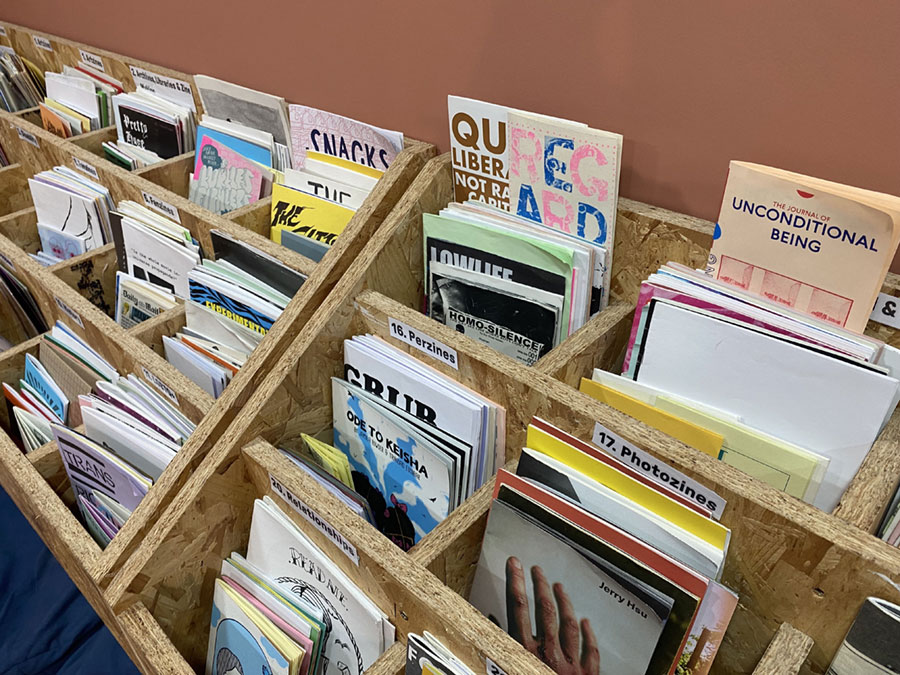 Wooden racks holding a variety of different zines