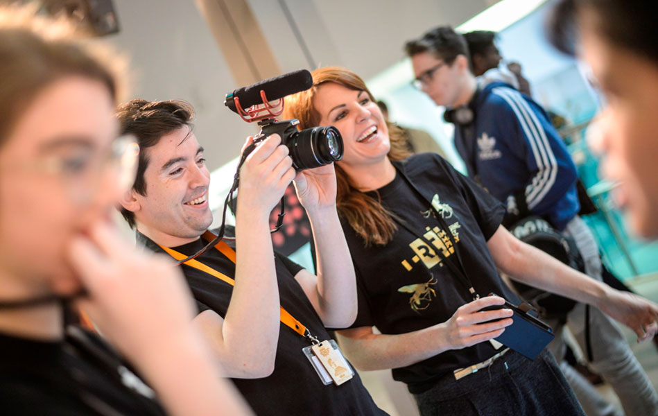 A group of young adults making a film using a digital camera.