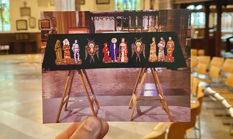 A hand holding a photograph of a coffin on display in a cathedral, within that same cathedral