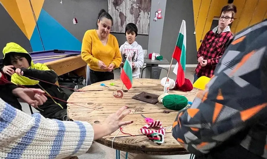 People stand around a table doing craft activities