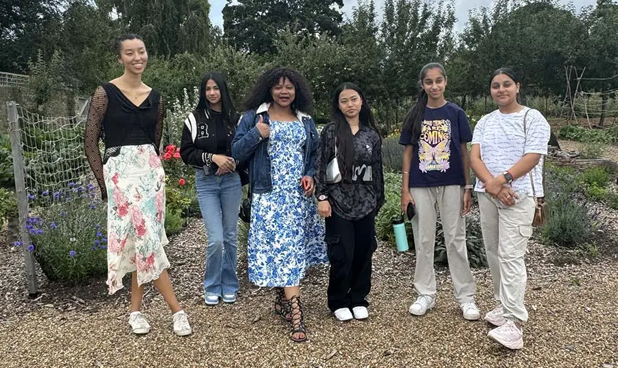 A group of six young people standing in a garden