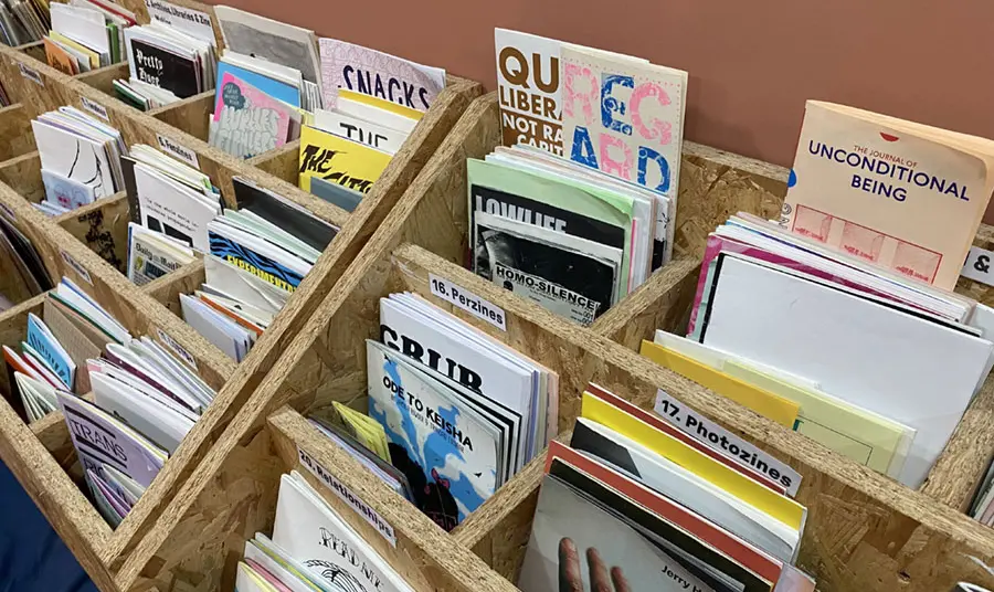 Wooden racks holding a variety of different zines