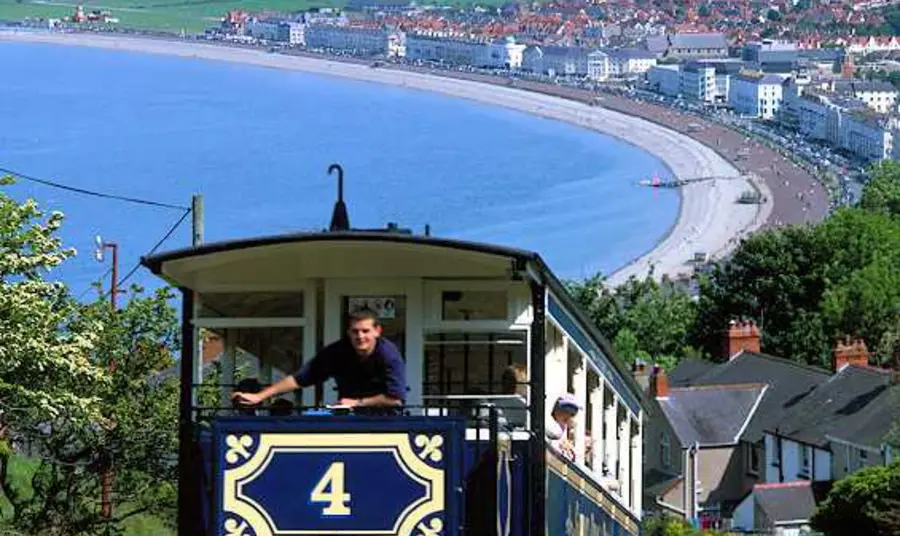 The tram on its way to the summit with a view of a beach below