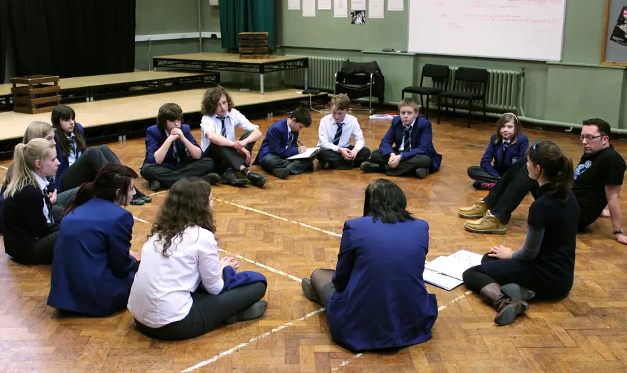 Students discuss ideas in a circle 