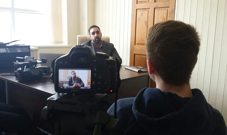 Young volunteer interviewing participant on the subject of their experience of British life
