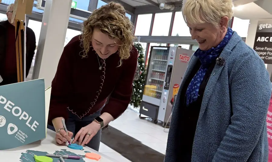A member of the council team speaks to a member of the community, looking over and annotating a map of the area together.