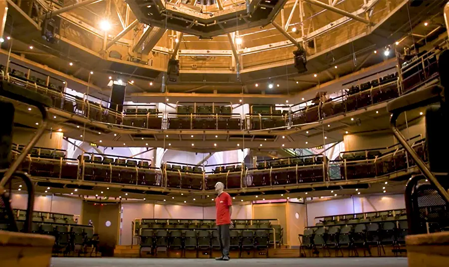 A man standing inside a vast theatre