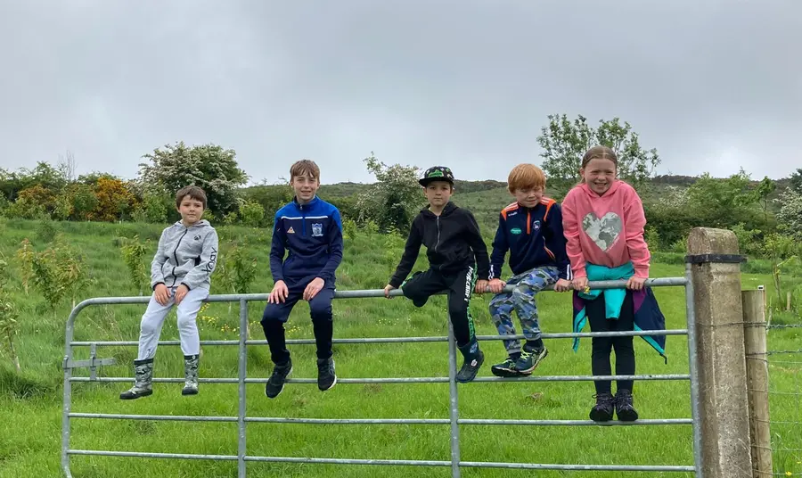 Young people resting on a gate in Brian's Wood