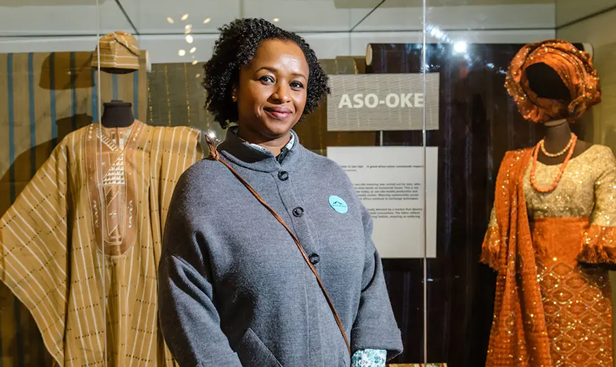 A curator in front of display of African costume