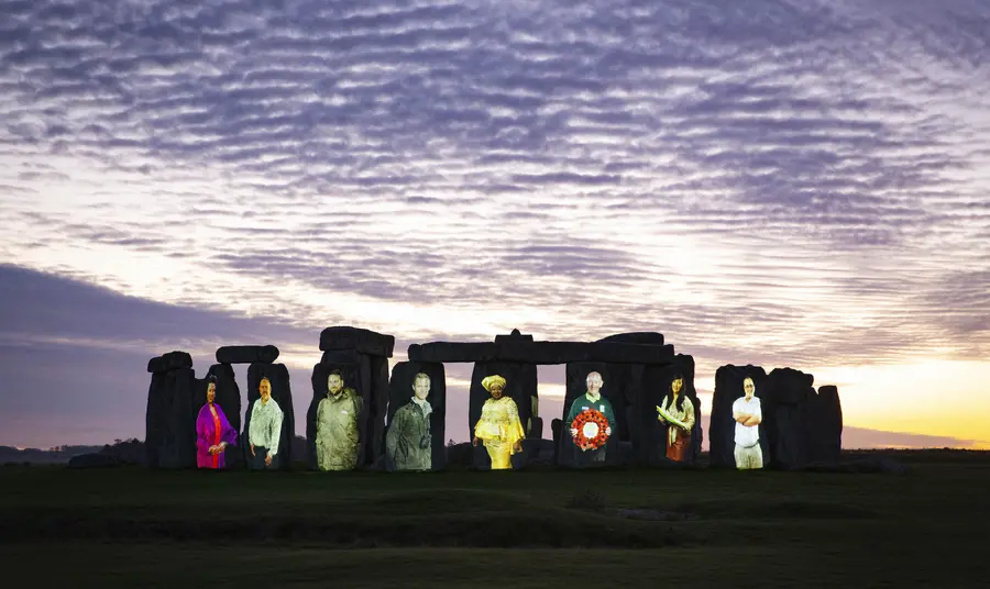 Stonehenge at sunset illuminated with eight people