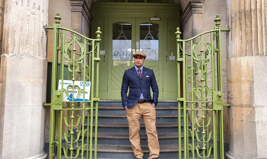 Man standing in front of the doorway of an old school building