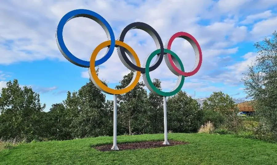 An outdoors sculpture of five coloured rings 