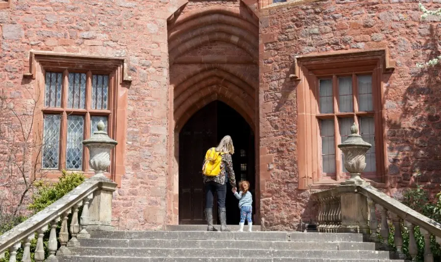 Adult and child entering historic building.