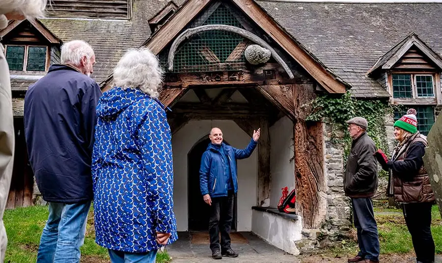 An outdoor scene of a person welcoming a group of people to a church