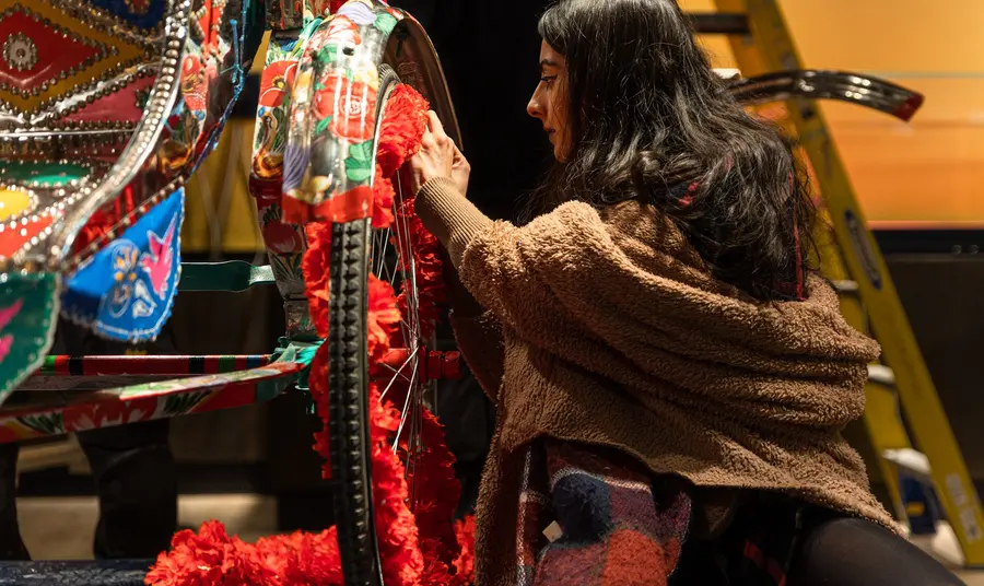 Person painting a rickshaw on display in the South Asia Gallery at Manchester Museum