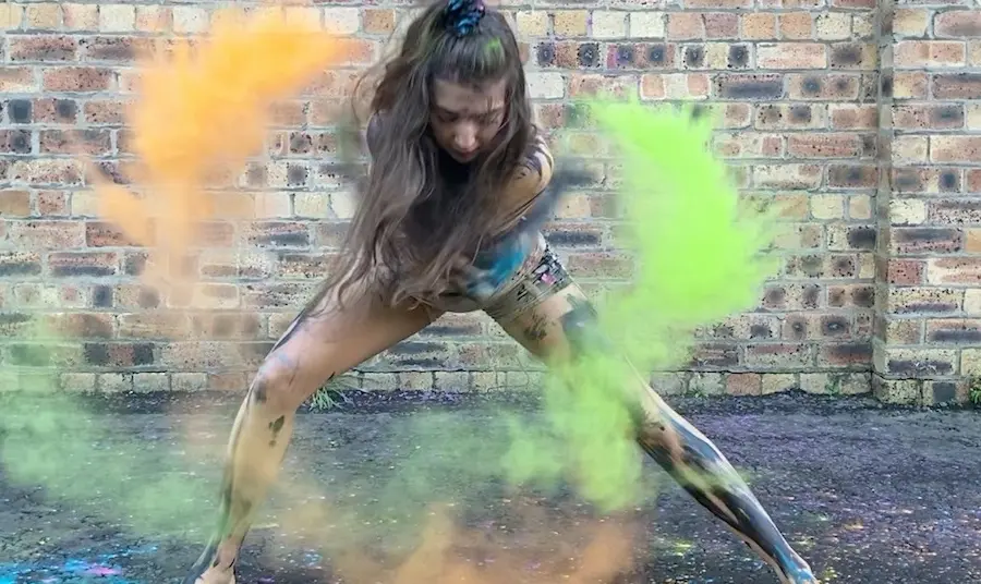 A young Shaper/Caper dancer from Dundee performs with coloured, powdered paint