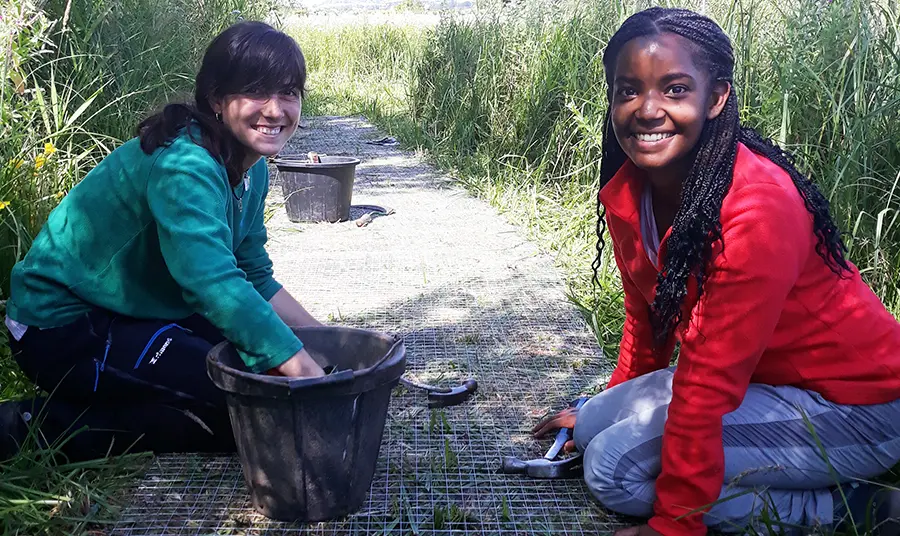 Two women working on a path at a wildlife reserve