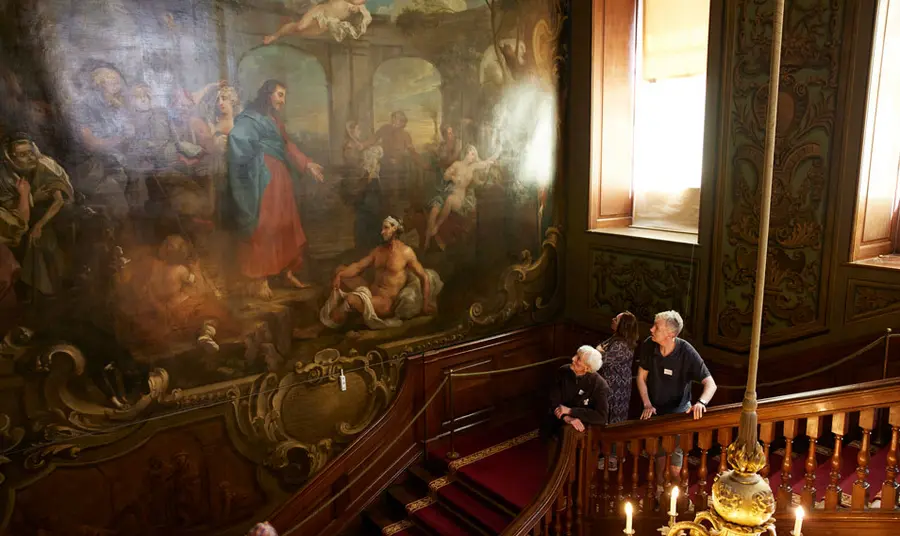 Visitors stand on the Hogarth Stair and look up at The Pool of Bethesda painting