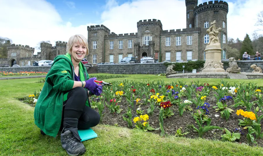 Woman crouching in grounds of a castle