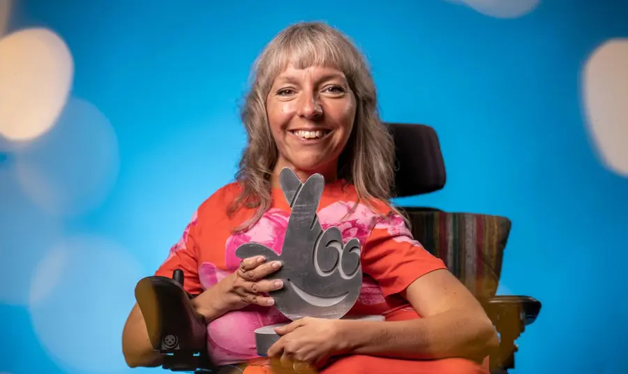 Esther Fox holding a metallic cross-fingers award