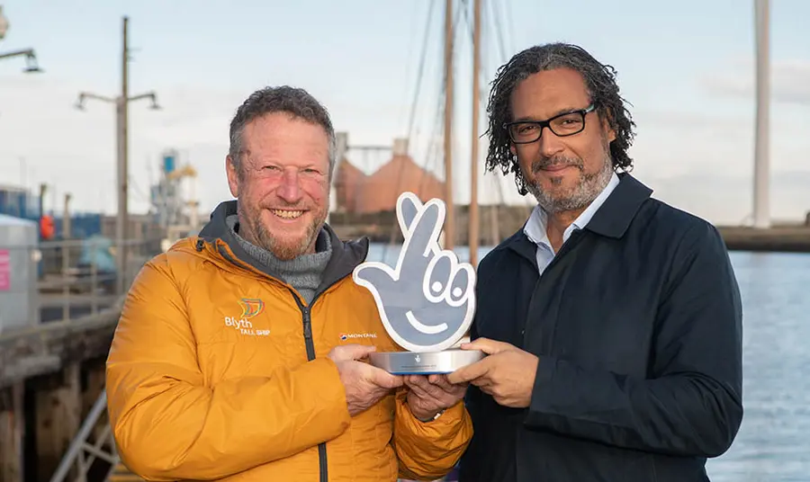Clive Gray from Blyth Tall Ships accepts a National Lottery Award from historian David Olusoga