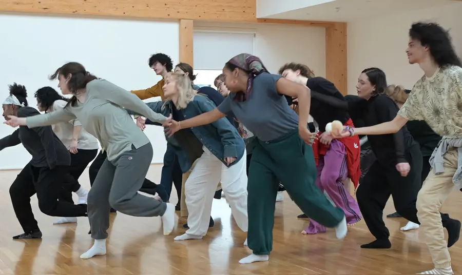 A group of people are in a studio taking part in a movement and dance workshop