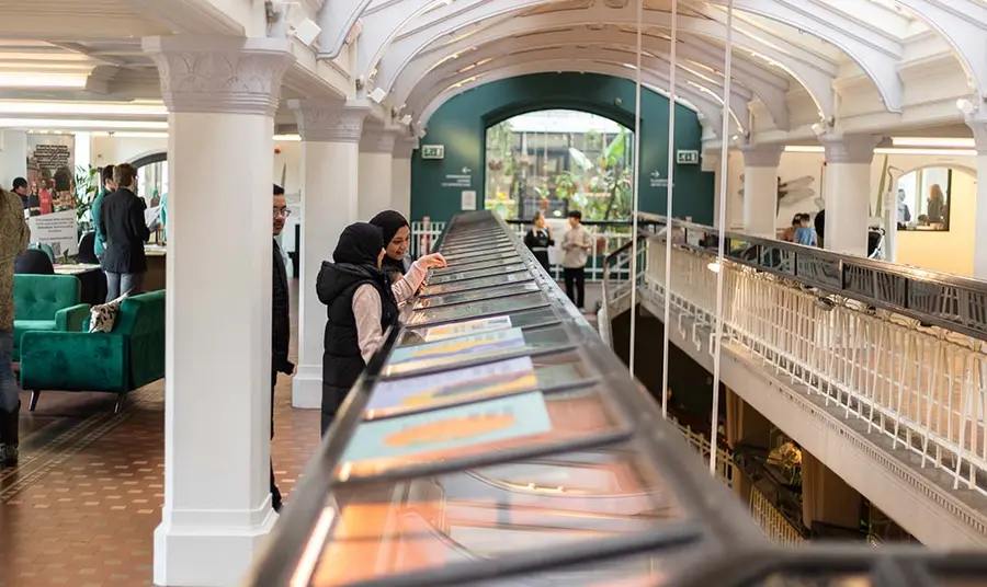 People looking at display cases in a mezzanine gallery.
