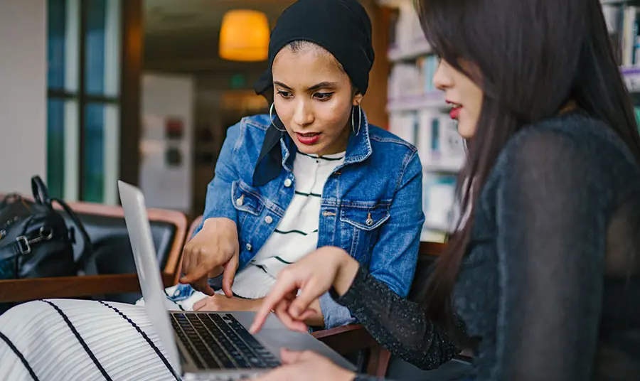 Two people looking at a laptop