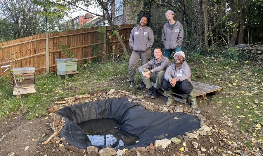 Four members of the Froglife team stand around a newly built pond