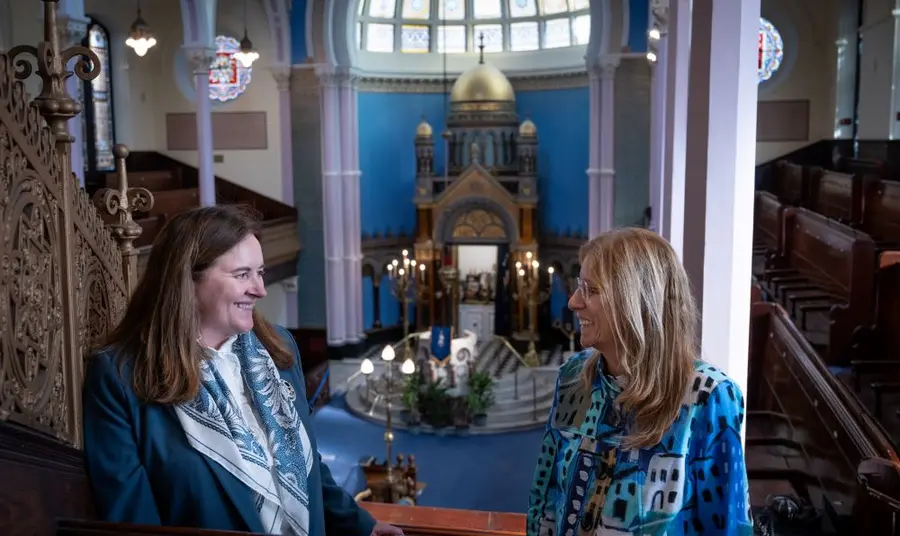 Two people standing on an internal balcony in Glasgow's Garnethill synagogue
