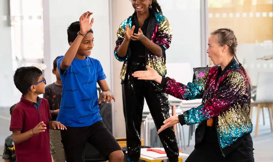 Two young boys taking part in a performance with two women. Photo credit: Andrew Baker.