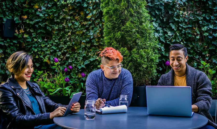 Three people using laptop and tablet