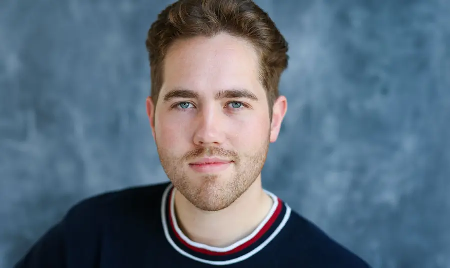 A studio portrait of a man with short brown hair