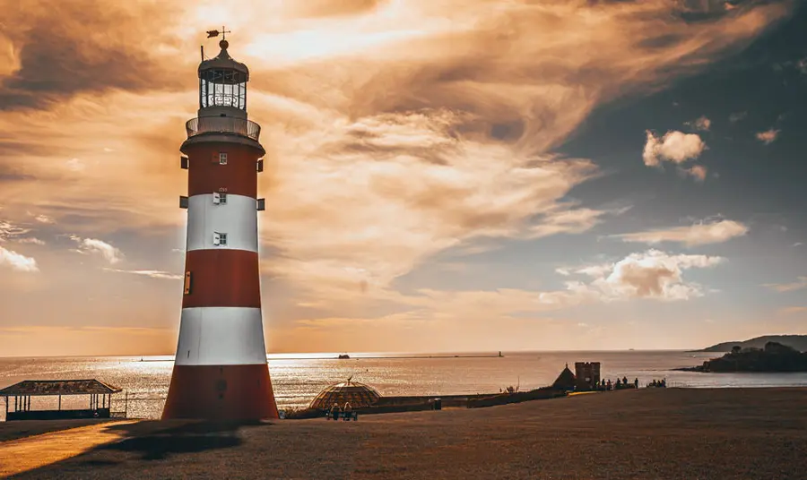 A red and white lighthouse at sunset