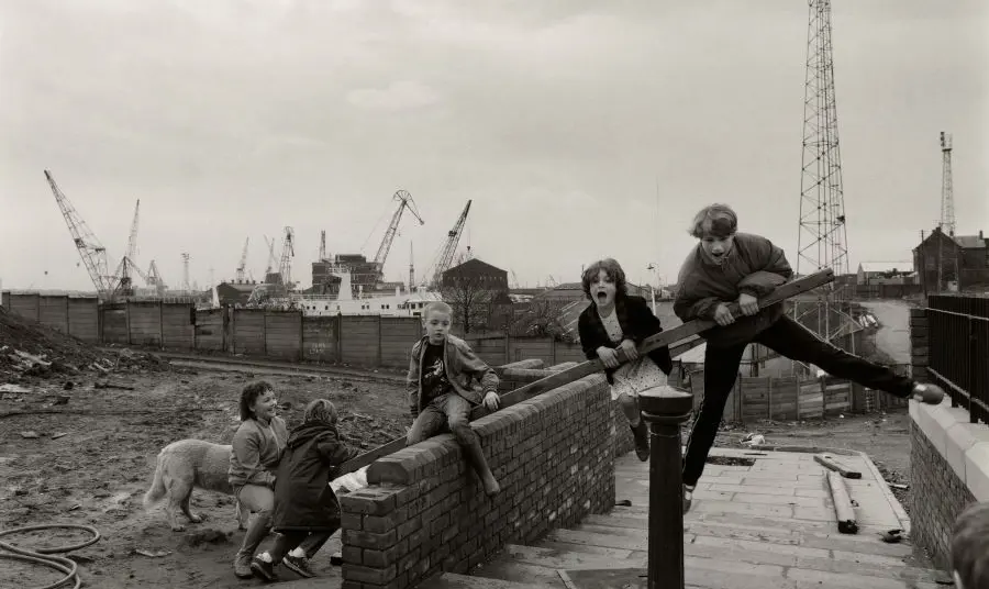 A black and white image of children playing in an industrial area.