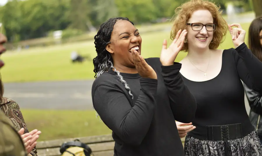 Young people clapping and laughing in the sun