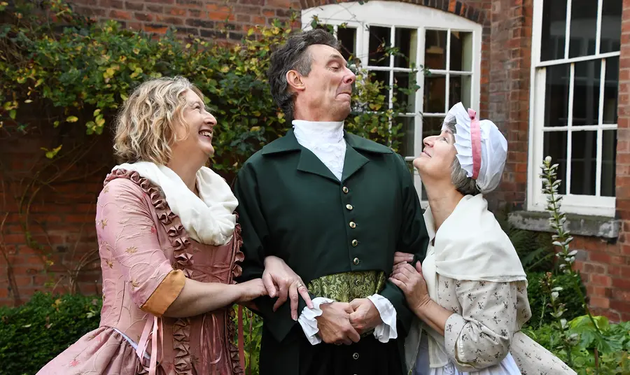 Three people in 18th-century costume