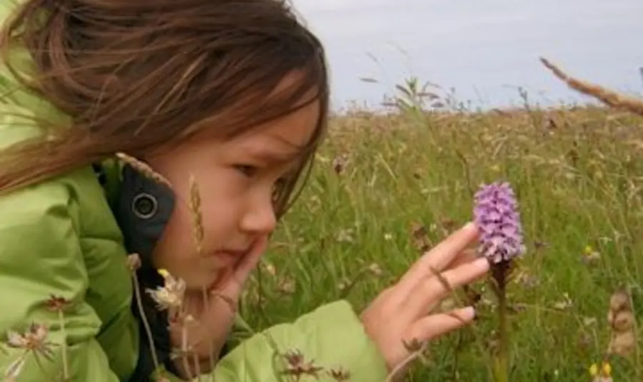 Girl looking at an orchid