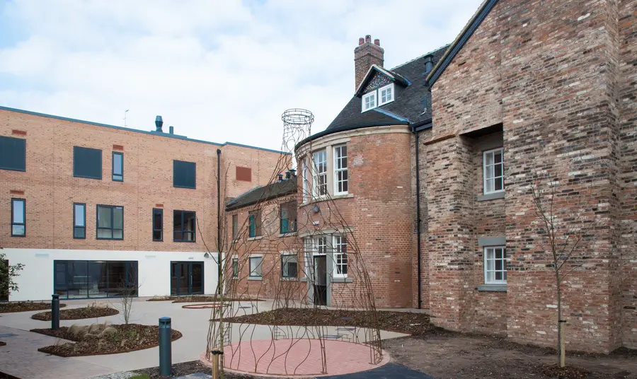 An old two-story brick building surrounds a paved courtyard 