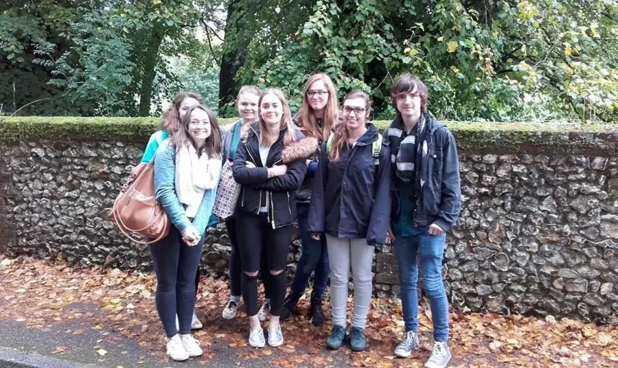 A group of young people in front of a wall