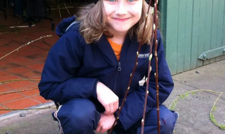 A young person taking part in willow weaving 