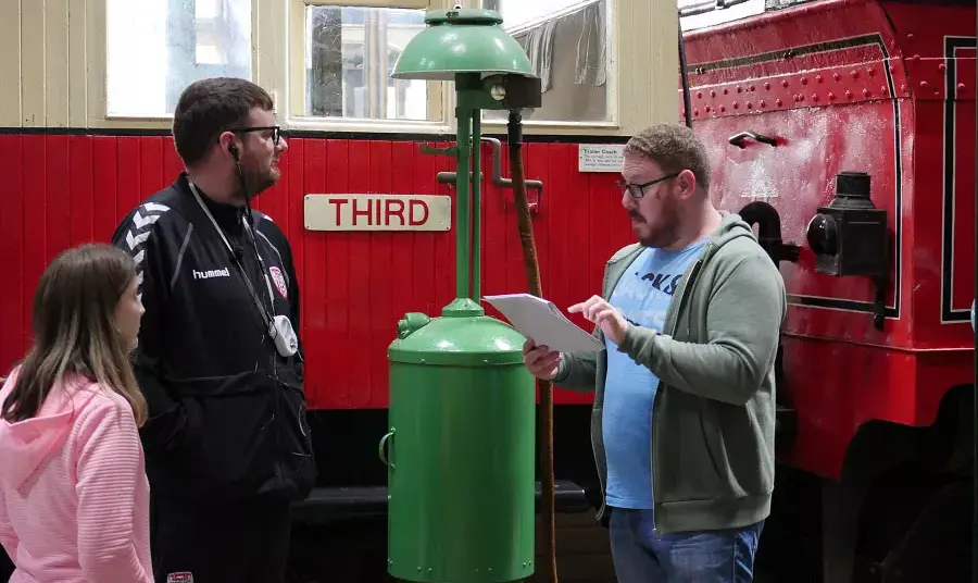 A person trains two people in giving a museum tour