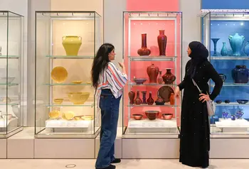 Two women looking at a museum display of ceramics