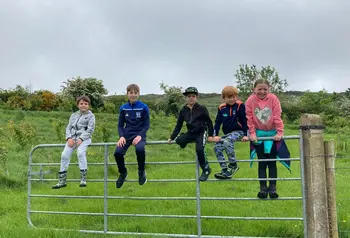 Young people resting on a gate in Brian's Wood