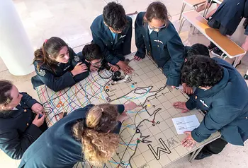 children gather round map of England