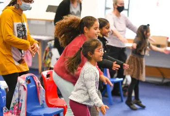 Children and adults dancing and smiling