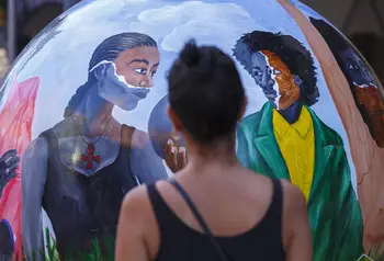 Person looking at a brightly coloured globe sculpture