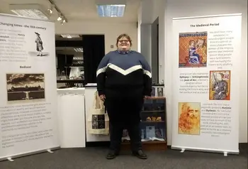 Person standing in front of a display of roller posters